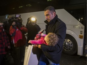 Syrian refugees arrive by bus to a hotel on Dixon Rd. near Toronto Pearson International Airport in Toronto, Ont.  on Friday December 11, 2015. E