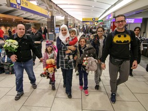 Syrian refugees, dad Asiad and mom Nour walk through Calgary International Airport to their new home in Canada in Calgary on Friday Dec. 18, 2015.
