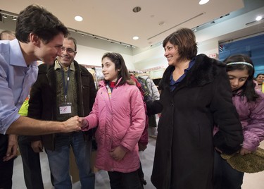 Canadian Prime Minister Justin Trudeau greets newly-arrived Syrian refugees Lucie Garabedian, centre, her father Vanig Garabedian, second left, mother Anjilik Jaghlassian, second right, and sister Anna-Maria Garabedian, right, at Pearson International airport, in Toronto, on Friday, Dec. 11, 2015.