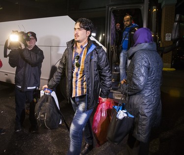 Syrian refugees arrive by bus to a hotel on Dixon Rd. near Toronto Pearson International Airport in Toronto, Ont.  on Friday December 11, 2015.