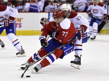 Washington Capitals right wing T.J. Oshie (77) skates with the puck against Montreal Canadiens center Torrey Mitchell (17) during the first period of an NHL hockey game Saturday, Dec. 26, 2015, in Washington.