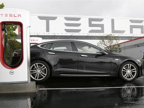 In this May 14, 2015 photo, a Tesla vehicle, named in honour of Serbian American inventor Nikola Tesla, is parked at a charging station outside of the Tesla factory in Fremont, Calif.