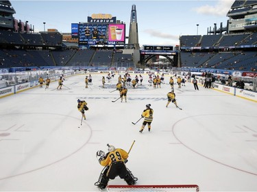 The Boston Pride, foreground, warm up before a women's outdoor hockey game against the Montreal Les Canadiennes at Gillette Stadium in Foxborough, Mass., Thursday, Dec. 31, 2015, where the Boston Bruins will play the Montreal Canadiens in the NHL Winter Classic on Friday.
