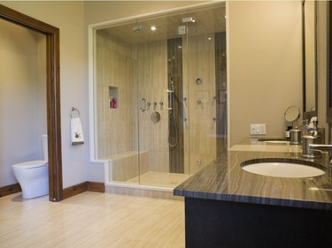 The main bathroom features a glass shower stall for two, his and hers wash basins plus his and hers lavatories. (Photo by Perry Mastrovito)