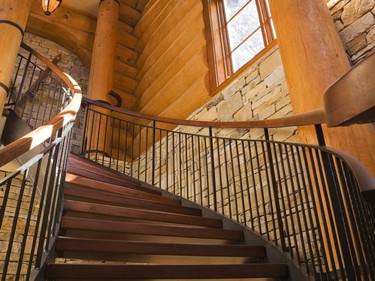The staircase curls up gracefully towards the upper floor, where the original master suite is located and now set aside for guests. (Photo by Perry Mastrovito)