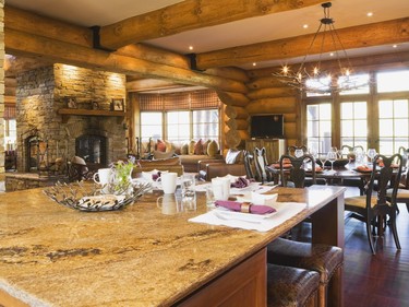 The warm tones in the granite countertop of the kitchen island matches the logs perfectly. (Photo by Perry Mastrovito)