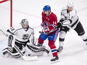 Canadiens' Tomas Plekanec (14) tries to deflect a shot past Kings goalie Jonathan Quick as he is guarded by defenceman Brayden McNabb during first period NHL hockey action, in Montreal, on Thursday, Dec. 17, 2015.