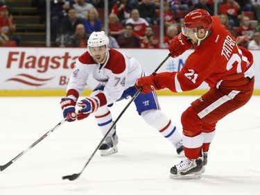 Detroit Red Wings left wing Tomas Tatar (21) shoots as Montreal Canadiens defenceman Alexei Emelin (74) defends in the second period of an NHL hockey game Thursday, Dec. 10, 2015 in Detroit.