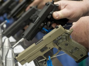 Semi-automatic handguns are displayed at an NRA meeting in 2014.