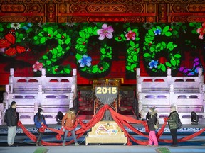 Workers push a 2016 countdown clock into position during a rehearsal for a New Year's Eve countdown celebration at the Imperial Ancestral Temple in Beijing, Wednesday, Dec. 30, 2015. At 8 hours ahead of Greenwich Mean Time, China will ring in 2016 ahead of much of the rest of the world on Thursday night.