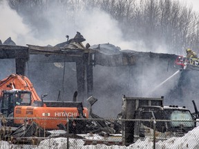 Firefighters from several off island communities battle a large fire at a Rona hardware store in Les Cèdres, 40 km west of Montreal Sunday, Jan. 3, 2016. The fire started around midnight and required firefighters to truck in water as the area is not serviced by water hydrants. The large store was completely destroyed and firefighters were still battling pockets of flames 12 hours later.