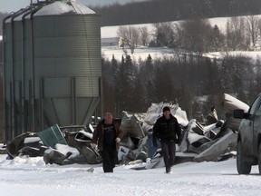 Businessman Mario Cote, left, walks with an employee near the building rubble of Brome Lake Ducks company in Racine on Monday January 4, 2016 where roughly 50,000 ducks died in a fire the previous Friday.