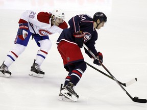Columbus Blue Jackets' Brandon Saad, right, works for the puck against Montreal Canadiens' Jeff Petry during the third period of an NHL hockey game in Columbus, Ohio, Monday, Jan. 25, 2016. The Blue Jackets won 5-2.