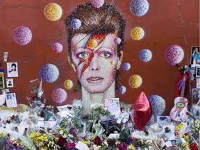 Floral tributes are placed in front of a mural of British singer David Bowie, painted by Australian street artist James Cochran, aka Jimmy C, in Brixton, south London on January 15, 2016.