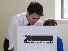 Liberal leader Justin Trudeau carries his vote to the ballot box accompanied by his son Xavier on October 19, 2015 in Montreal.