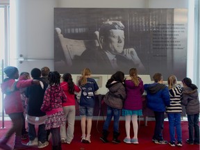 Children gather around a a multimedia display "John F. Kennedy His Life and Legacy" in the grand foyer at the John F. Kennedy Center for the Performing Arts in Washington, Friday, Nov. 22, 2013, on the 50th anniversary of President John F. Kennedy's death.