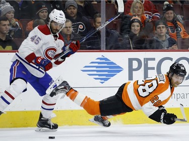 Philadelphia Flyers' Claude Giroux, right, falls after a hit from Montreal Canadiens' Mark Barberio during the second period of an NHL hockey game, Tuesday, Jan. 5, 2016, in Philadelphia.