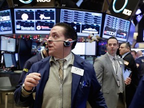 Trader Tommy Kalikas, centre, works on the floor of the New York Stock Exchange, Monday, Jan. 4, 2016.
