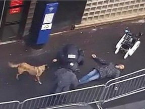 This video grab image taken from footage obtained by AFP shows a police and an anti-explosive robot standing beside the body of a man shot dead in front of a police station on January 7, 2016 in Paris.