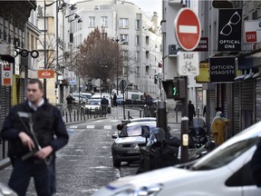 French policemen stand guard at Rue de la Goutte d'Or in the north of Paris on January 7, 2016, near the site where police shot a man dead as he was trying to enter a police station. French police shot dead the knife-wielding man as he attacked a police station in Paris, a year to the day since jihadist gunmen killed 12 people at Charlie Hebdo newspaper. The man reportedly shouted "Allahu Akbar" (God is Greatest) and was wearing what appeared to be an explosives vest although it was later found to be a fake, police and government sources said.