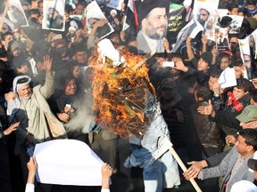 Supporters of Iraqi Shiite cleric Moqtada al-Sadr (portrait, top-centre) burn an effigy of a member of the Saudi ruling family as others hold posters of prominent Shiite cleric Nimr al-Nimr during a demonstration in the capital Baghdad on January 4, 2016, against Nimr's execution by Saudi authorities. Sunni-ruled Saudi Arabia severed diplomatic ties with Shiite-dominated Iran, its long-time regional rival, after angry demonstrators attacked the Saudi embassy in Tehran and its consulate following Nimr's execution.