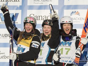 Moguls winner Justine Dufour-Lapointe is flanked on the podium by her sisters, second place Chloe, left, and third place Maxime, right, at the FIS Freestyle Ski World Cup Saturday, January 23, 2016 in Val St-Come, Que.
