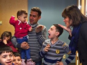 Quebec Immigration Minister Kathleen Weil greets members of a Syrian family as she meets refugees at CEGEP Ste-Foy, in Quebec City, Tuesday Jan. 12, 2016.