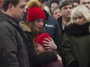 Olivia Carrier comforts her younger sister Frédérique at a vigil held in Lac Beauport near Quebec City Monday, January 18, for the victims of a terror killing in Burkina Faso that included their grandparents Yves Carrier and Gladys Chamberland and their aunt and uncle Maude and Charlelie Carrier.
