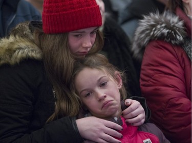 Olivia Carrier comforts her younger sister Frédérique at a vigil held in Lac Beauport Monday, January 18 for the victims of a terror killing in Burkina Faso that included their grandparents Yves Carrier and Gladys Chamberland and their aunt and uncle Maude and Charlelie Carrier.