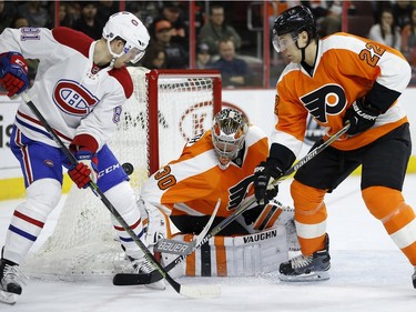 Montreal Canadiens' Lars Eller, left, cannot get a shot past Philadelphia Flyers' Michal Neuvirth, center, as Luke Schenn defends during the first period of an NHL hockey game, Tuesday, Jan. 5, 2016, in Philadelphia.