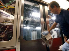 Maintenance worker Gilles Desjardins wipes graffiti off the doors and windows of a métro car in Montreal in 2007.