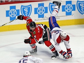 Jeff Petry of the Canadiens falls over the back of Niklas Hjalmarsson of the Chicago Blackhawks at the United Center on Jan. 17, 2016, in Chicago.