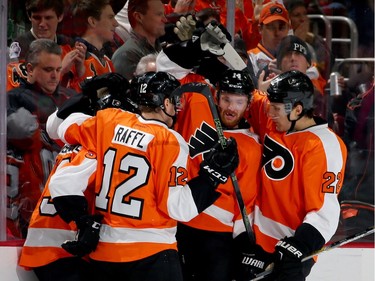 Brayden Schenn of the Philadelphia Flyers is congratulated by teammates Michael Raffl #12, Sean Couturier #14 and Luke Schenn #22 after he scored a goal in the first period against the Montreal Canadiens at the Wells Fargo Center on January 5, 2016 in Philadelphia, Pennsylvania.