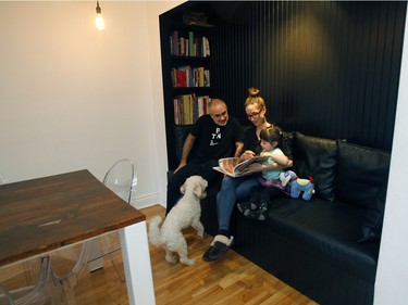 Agnes Dupuis, Francois Xavier Saint Georges, left , their 4 years old daughter Justine and the dog Gaston, sit in an area for the kids to read. They are sitting on a black vinyl-covered, built-in sofa and rows of books on either side. That area used to be a closet. (Marie-France Coallier / MONTREAL GAZETTE)
