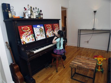Agnes Dupuis, Francois Xavier Saint Georges's  4-year-old daughter Justine plays the piano at home.  The coffee table in the open double living room is made of chunks of rough wood. (Marie-France Coallier / MONTREAL GAZETTE)