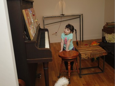 Agnes Dupuis, François Xavier Saint Georges's daughter Justine stands by the piano at home. (Marie-France Coallier / MONTREAL GAZETTE)