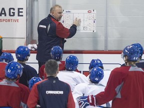 Canadiens coach Michel Therrien discusses strategy with his players during practice at the Bell Sports Complex in Brossard on Dec. 8, 2015.