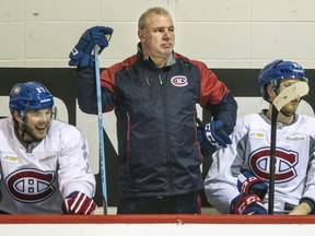 Canadiens coach Michel Therrien stands on the bench between Alex Galchenyuk, left, and Lars Eller during practice at the Bell Sports Complex in Brossard on Jan. 3, 2016.