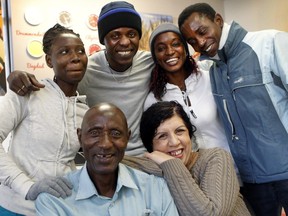 A Senegalese father, Boubacar Sidi Diatta, (bottom left) poses for a photograph with Fouzia Benelhadj Djelloul , bottom right, who helps newcomers settle in Drummondville, and his four children at Les Goûts du Monde in Drummondville. His children: left to right: Kady Diatta, 19, Biram Diatta, 35, Kine Diatta, 33, and Moussa Diatta, 30, far right. The family just arrived in Drummondville two months ago and were welcomed by RID, the intercultural committee in Drummondville.