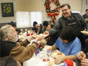 Montreal Mayor Denis Coderre, right, serves a meal to Murray Nicol, on Sunday at the Accueil Bonneau shelter during the annual Dîner des rois.