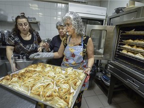 Volunteers help to prepare Christmas lunch for Syrian Armenian refugees at St. Gregory the Illuminator Cathedral in Montreal on Sunday, Jan. 10, 2016.