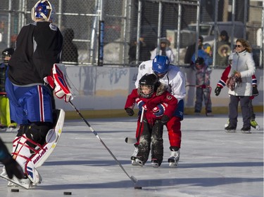 Montreal Canadiens centre David Desharnais helps a young skater from Ecole Leon Guilbault in Parc Emile in Laval on Monday, Jan. 11, 2016. The Canadiens practiced on the new Montreal Canadiens Foundation Blue Blanc Rouge rink in the park after the opening ceremony.