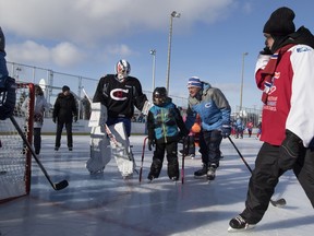 Montreal Canadiens goalie Ben Scrivens and assistant coach Clément Jodoin help a young skater at Parc Émile in Laval on Jan. 11, 2016.