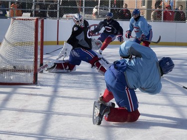 Montreal Canadiens right wing Devante Smith-Pelly, bottom centre, scores against goalie Ben Scrivens in Parc Emile in Laval on Monday, Jan. 11, 2016. The team was practicing on the new Montreal Canadiens Foundation Blue Blanc Rouge rink that opened today. Centre Paul Byron, second from left, and Sven Andrighetto look on.