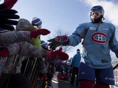 Montreal Canadiens Sven Andrighetto gives school kids a high-five in Parc Emile in Laval on Monday, Jan. 11, 2016. The Canadiens practiced on the new Montreal Canadiens Foundation Blue Blanc Rouge rink in the park after the opening ceremony.