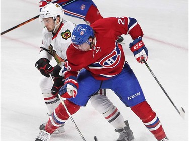 Montreal Canadiens defenceman Jeff Petry and Chicago Blackhawks defenceman Niklas Hjalmarsson (4) try to get at puck flying through their legs during second period NHL action in Montreal on Thursday January 14, 2016.