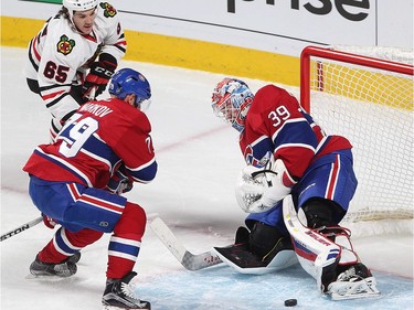 Montreal Canadiens goalie Mike Condon stops puck next to teammate Andrei Markov and Chicago Blackhawks centre Andrew Shaw (65) during first period NHL action in Montreal on Thursday January 14, 2016.