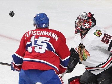 Montreal Canadiens left wing Tomas Fleischmann (15) and Chicago Blackhawks goalie Corey Crawford look at flying puck sailing next to them  during second period NHL action in Montreal on Thursday January 14, 2016.