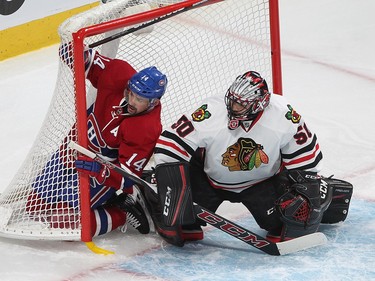 Montreal Canadiens' Tomas Plekanec (14) slides into net next to Chicago Blackhawks goalie Corey Crawford during third period NHL action in Montreal on Thursday January 14, 2016.