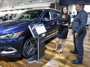 Alexandra Seewaldt talks to a client interested in an Infiniti QX60 at the 2016 Montreal International Auto Show at the Palais des congrès in Montreal Monday January 18, 2016.